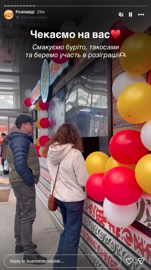 story z otwarcia: balony wzdłuż lady i klienci przy okienku, widziani od tyłu
