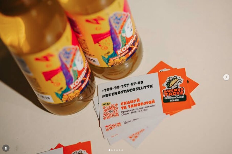 wizytówki obok butelek kompotu: kontakt, nazwa na instagramie i kod qr do zamówienia