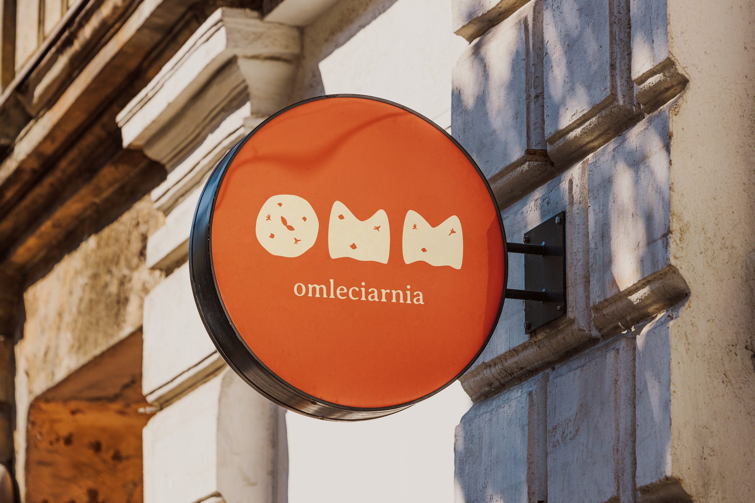 the round omleciarnia sign on a warsaw facade